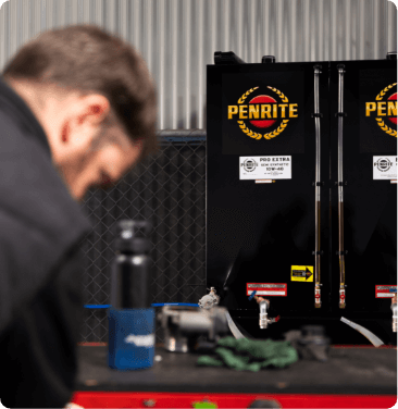 mechanic standing in front of engine oil tanks